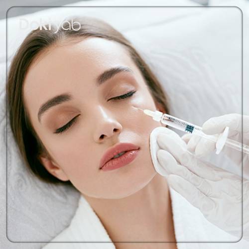 پزشک در حال تزریق فیلر به زیر چشم مراجع